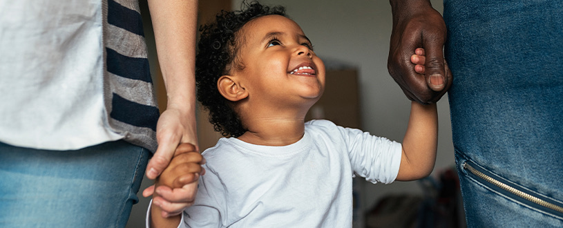 Child holding hands with parents