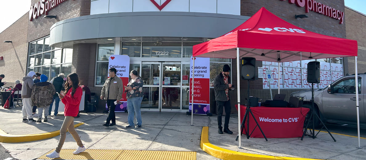 People gather around the exterior of a CVS store for a block party event.