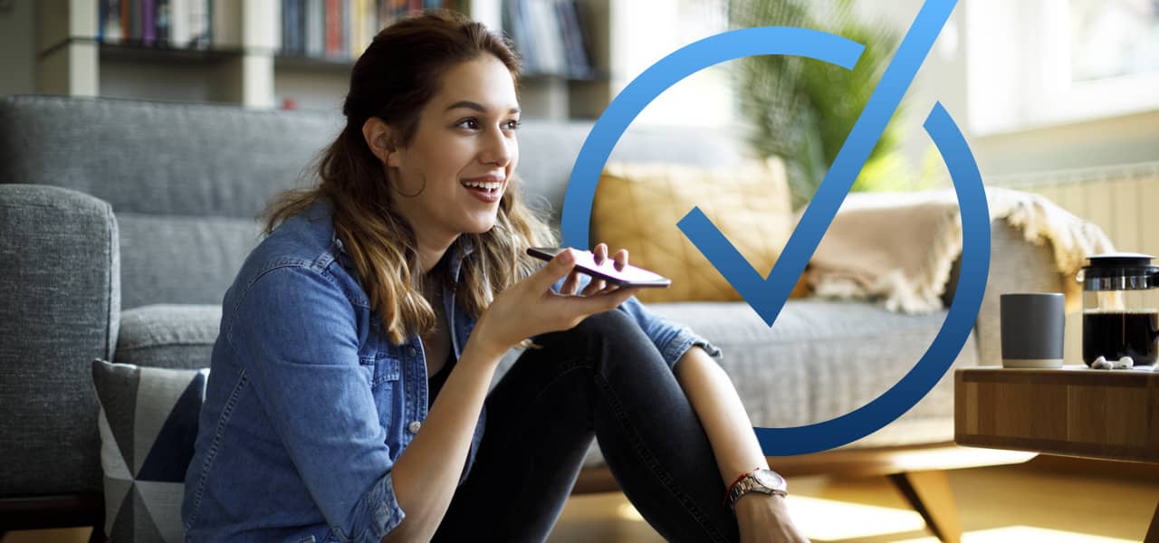 A person in their living room speaking on their cell phone and an oversize HSA/FSA checkmark symbol