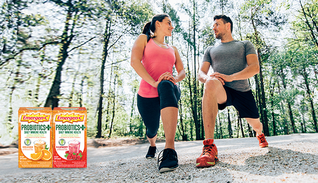 A man and a woman doing lunges. Product packages of Probiotics Plus fizzy drink mix in orange and raspberry flavors.