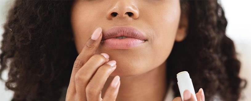 Woman putting on lip balm