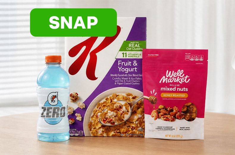 SNAP eligible grocery items displayed on a countertop, including cereal, a sports drink, and a snack mix, beneath a SNAP label.
