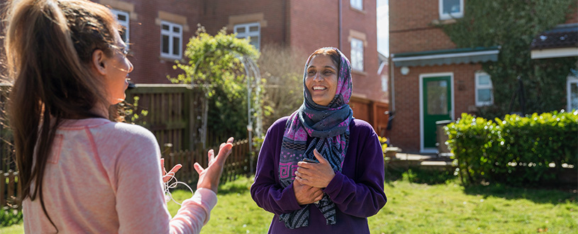 Two women talking in a backyard