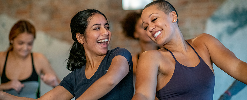 Two women dancing and smiling