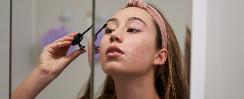 Woman putting on mascara